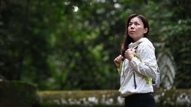 一个亚洲中国美丽的女人在丛林热带雨林徒步旅行视频素材