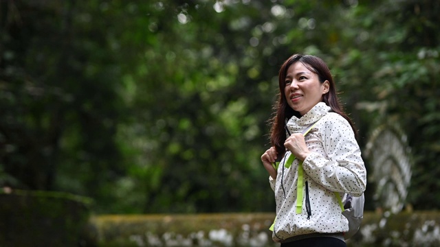 一个亚洲中国美丽的女人在丛林热带雨林徒步旅行视频素材