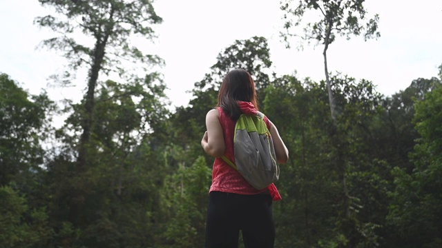 一位亚洲华人女性在看丛林风景视频素材