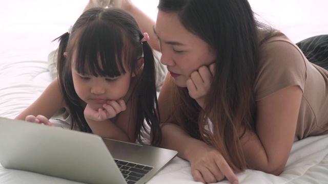 小女孩和她的妈妈在床上做鬼脸视频素材