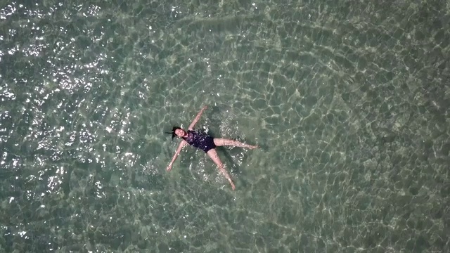 亚洲女人漂浮在海滩度假海视频素材