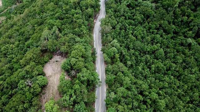 公路的鸟瞰图穿过绿色的森林在泰国清莱省的高地山脉。视频素材