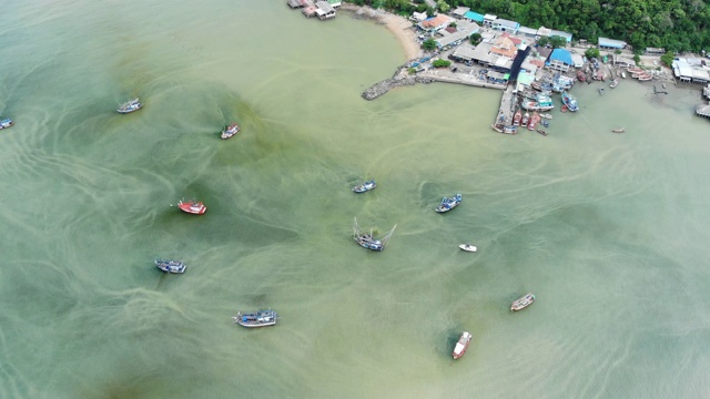 鸟瞰图/一艘沿着海岸排列并抛锚等待捕鱼时间的渔船。视频素材