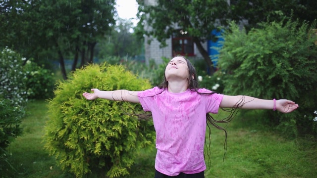 肖像快乐湿孩子在雨中花园在炎热的夏天视频下载