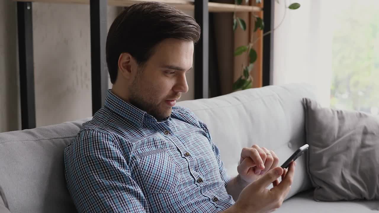 男人拿着智能手机收到好消息短信感到高兴视频素材