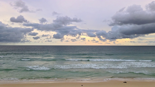 美丽的热带海滩日落后与云和海浪冲击空荡荡的海滩。泰国普吉岛海滩。视频素材