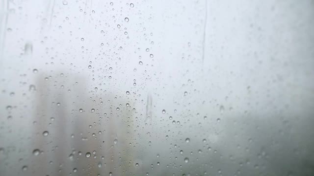 雨滴从窗户上流下的微距摄影。窗外的雨视频素材