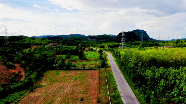 鸟瞰图的白色汽车行驶在乡村道路在森林。无人机在松树林的砾石路上飞行视频素材