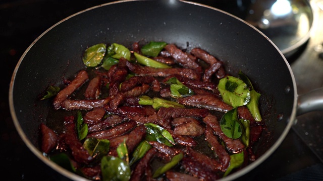 炸牛肉片配香草，晒干牛肉片在平底锅上炸视频素材