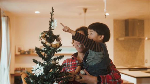 一位日本父亲正在和他的孩子们装饰圣诞树视频素材