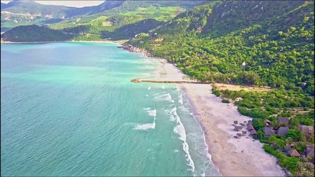 无人机沿着宽阔的海岸在宁静的海洋上空飞行视频素材