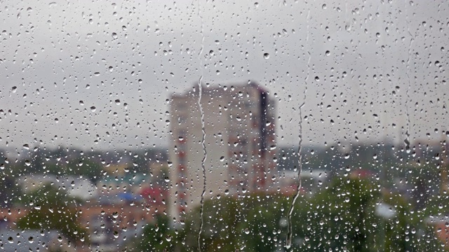 雨滴落在窗户上，模糊的城市景观作为背景视频下载