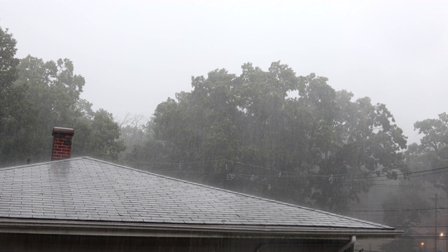 夏天，大雨倾盆，雨水从屋顶流到镇上视频素材