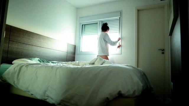 人在早晨开始新的一天的仪式，女人醒来打开窗户视频素材