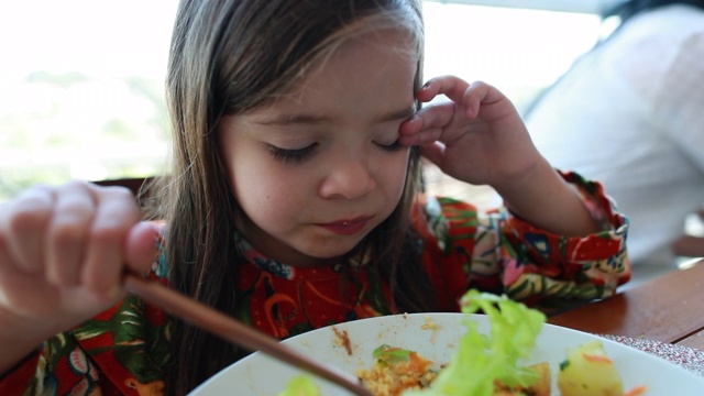 小女孩在吃午饭。孩子吃沙拉，孩子吃健康餐视频素材