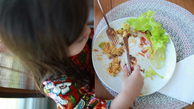 孩子在吃沙拉餐盘，小女孩在吃午饭，从上面看视频素材