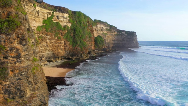 Uluwatu巴厘岛。蓝色的海洋和岩石山，覆盖着热带树木。视频素材