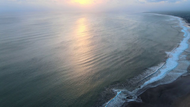 无人机拍摄的美丽的蓝色海浪在巴厘岛的沙滩景观视频素材