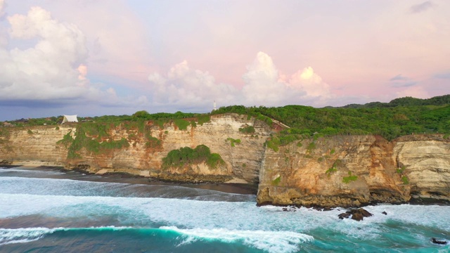 Uluwatu巴厘岛。蓝色的海洋和岩石山，覆盖着热带树木。视频素材