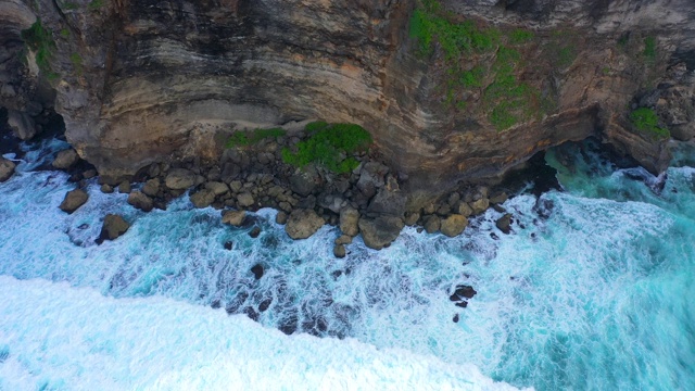 Uluwatu巴厘岛。蓝色的海洋和岩石山，覆盖着热带树木。视频素材