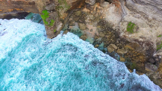 Uluwatu巴厘岛。蓝色的海洋和岩石山，覆盖着热带树木。视频素材