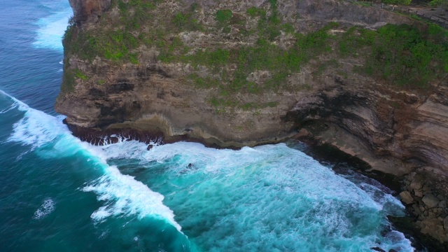 Uluwatu巴厘岛。蓝色的海洋和岩石山，覆盖着热带树木。视频素材