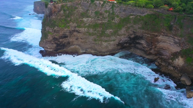 Uluwatu巴厘岛。蓝色的海洋和岩石山，覆盖着热带树木。视频素材