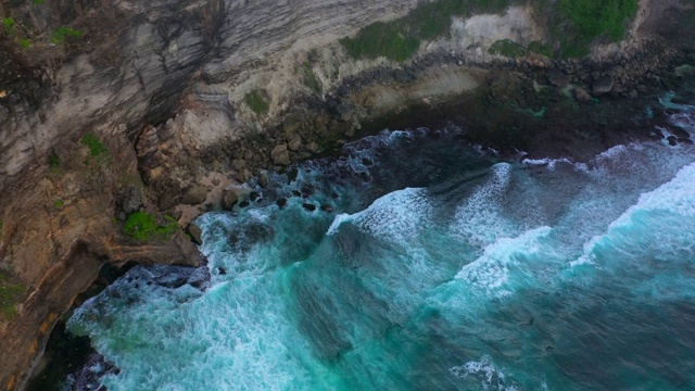 Uluwatu巴厘岛。蓝色的海洋和岩石山，覆盖着热带树木。视频素材