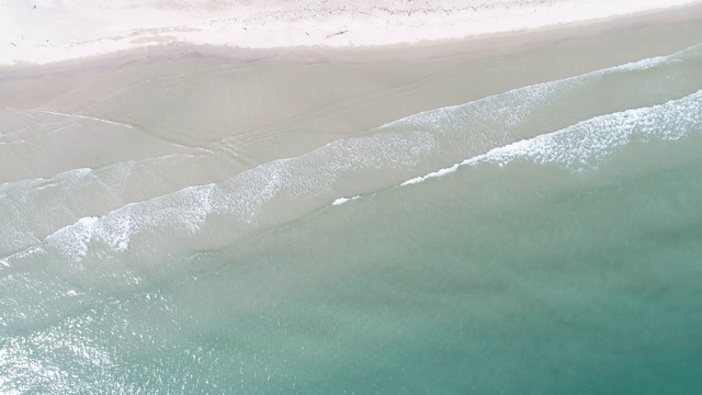 鸟瞰图海浪在白色的沙滩碧绿的海水椰子树视频素材