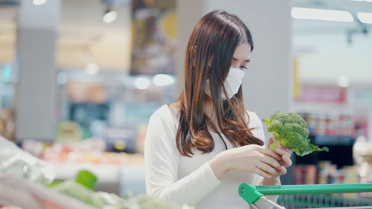 戴口罩的妇女在超市选购蔬菜视频素材