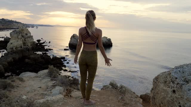 美丽的女人享受宁静的日落探索灵性抬头祈祷沉思的旅程，双臂拥抱生命视频素材