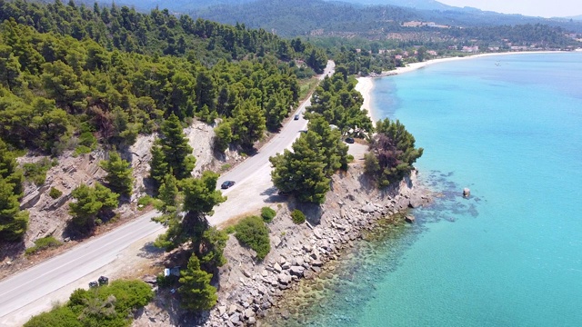 汽车在美丽的蓝色大海旁边的道路上行驶。异国风情夏日旅游概念。鸟瞰图视频素材