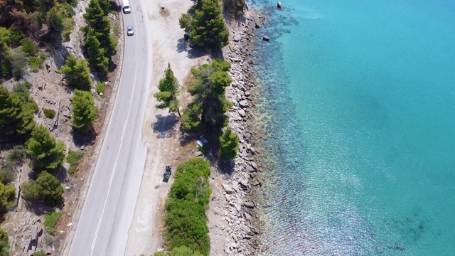 由绿松石透明的海洋在海岸上旅行的道路。空中鸟视图视频素材