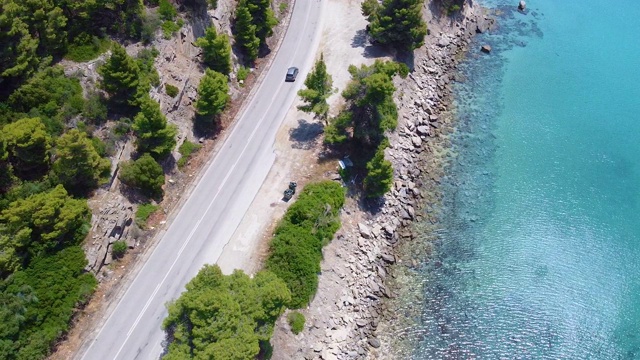 汽车行驶在道路上的岩石海岸在蓝色的海洋。鸟瞰图视频素材