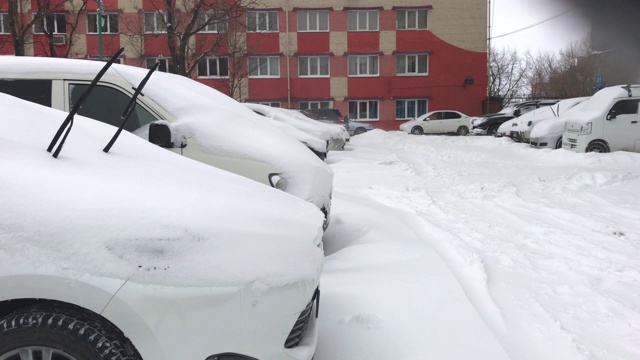 用手机拍的。一场暴风雪过后，汽车被雪覆盖视频素材