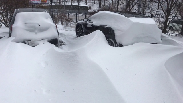 用手机拍的。一场暴风雪过后，汽车被雪覆盖视频素材