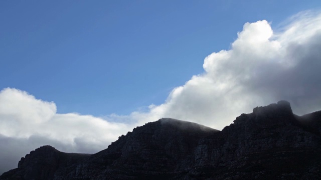 南非黑暗山峰上快速移动的云的时间流逝视频素材