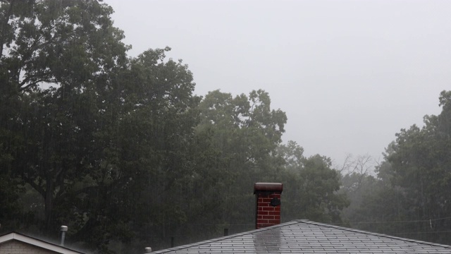 夏天的暴雨中雨点纷纷落下，镇上的屋顶上滴落着雨滴视频素材