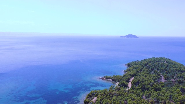 海岸边有美丽的自然风光和土路，远处还有小岛。鸟瞰图视频素材