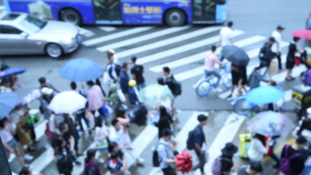 在中国人行道上的人和车的散焦视频素材