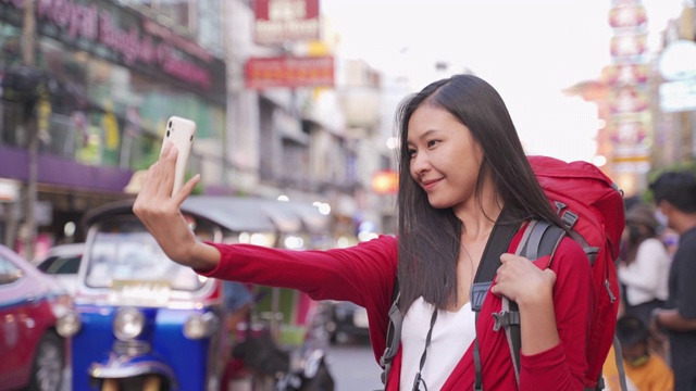 亚洲女摄影师，年龄20-30岁。在泰国徒步旅行时，穿着靴子自拍。视频素材