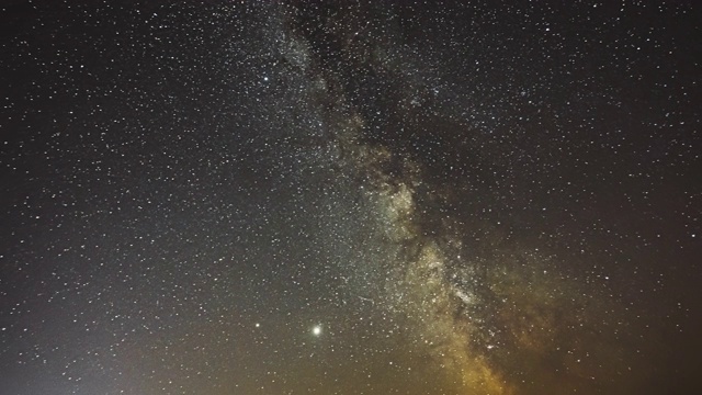 夜晚星空与发光的星星。明亮的辉光行星土星和木星在天空中的银河系恒星。夕阳下的天空，4K时间间隔视频素材