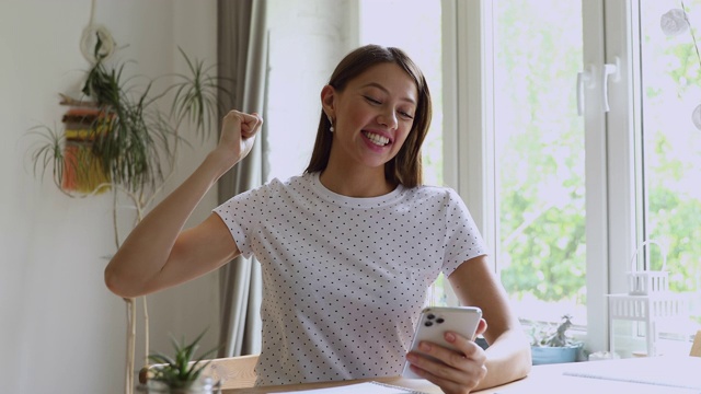 拿着智能手机看短信的女人喜出望外视频素材