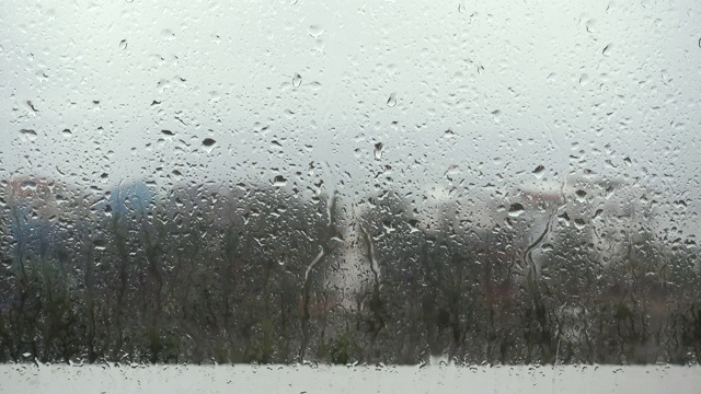 雨滴落在窗户上的特写镜头望向多云的阴雨天空视频下载