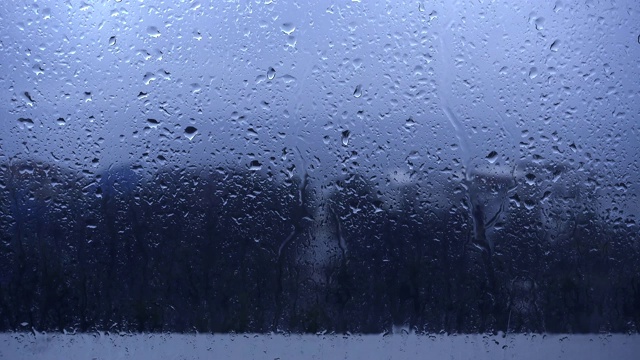 雨滴落在窗户上的特写镜头望向多云的阴雨天空视频下载