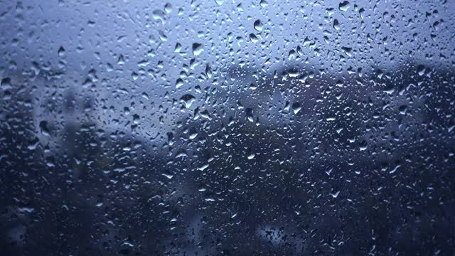 雨滴落在窗户上的特写镜头望向多云的阴雨天空视频下载