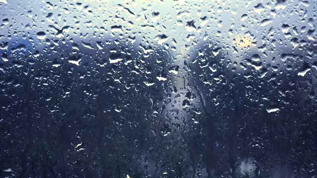 雨滴落在窗户上的特写镜头望向多云的阴雨天空视频下载