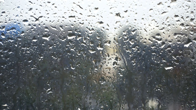 雨滴落在窗户上的特写镜头望向多云的阴雨天空视频下载