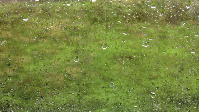 水滴落在玻璃上的特写镜头。多雨的天气背景。视频素材