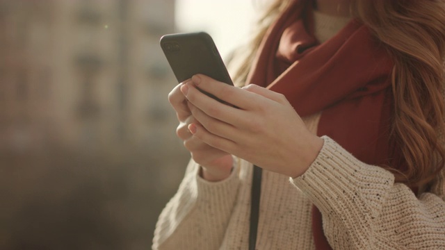 特写女人的手在户外使用电话。不认识的女孩拿着手机。视频素材